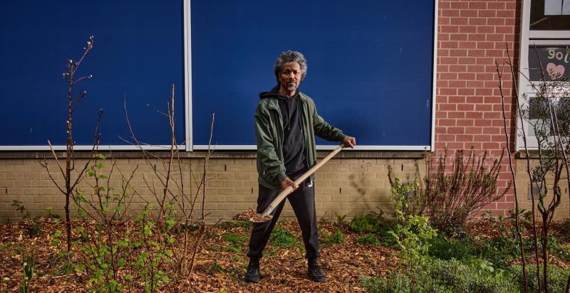 man met schep met houtsnippers