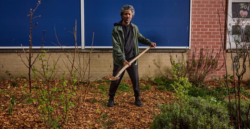 man met schep met houtsnippers