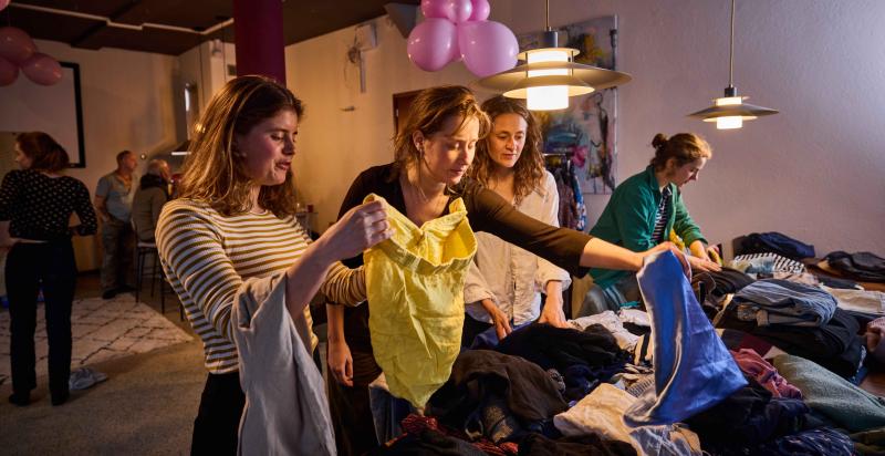 vier vrouwen bij een kledingruil
