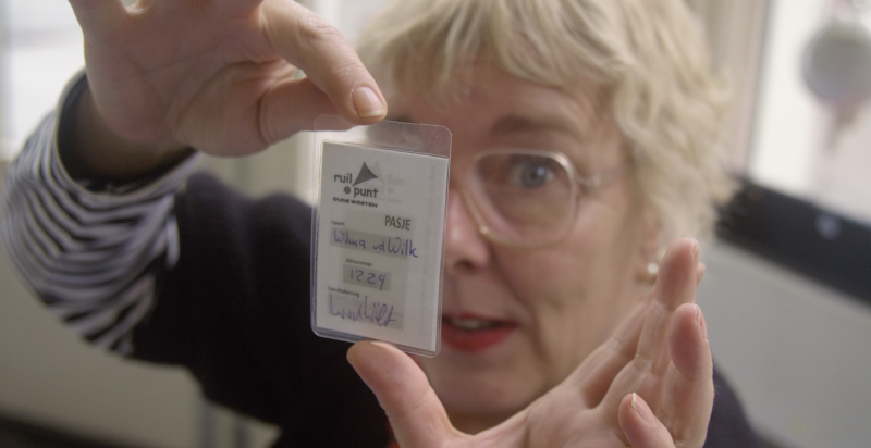 close-up foto van Wilma Kruger, voor haar gezicht houdt zij haar lidmaatschap pas van het ruilpunt.