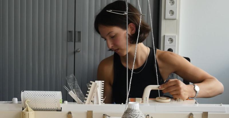 Rebekka Groeneveld achter een breimachine.