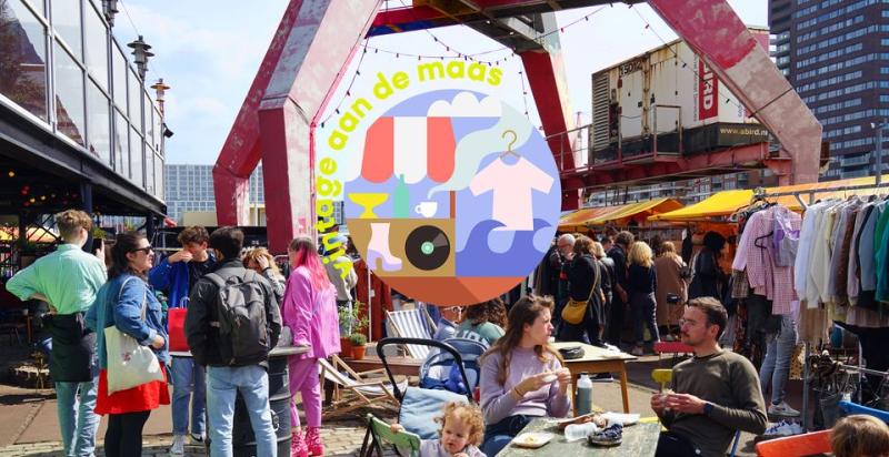 Een buitenmarkt met kraampjes en veel mensen.