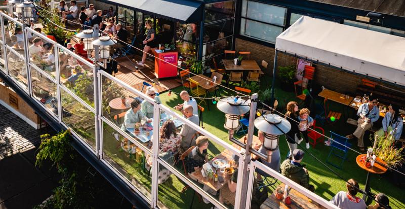 Op de foto een vol terras bij OASE Rotterdam