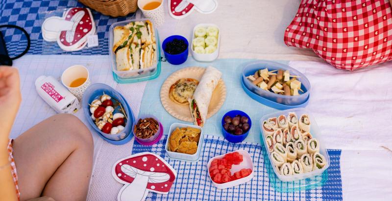 Eten in bakjes uitgestald op een picknick kleed