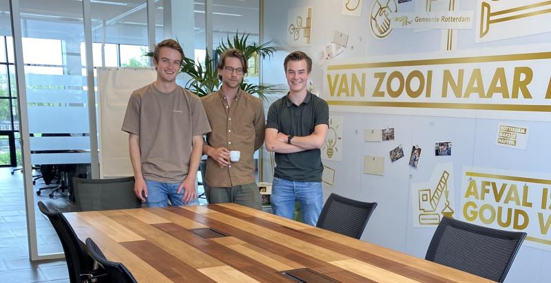 De drie studenten Elmar, Mels en Kaz staan achter hun zelf ontworpen vergadertafel.