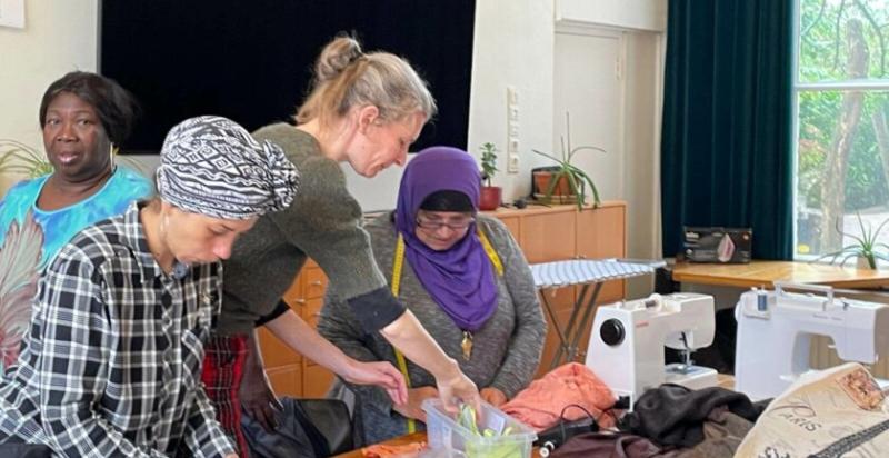 vier vrouwen aan het werk met een naaimachine en textiel