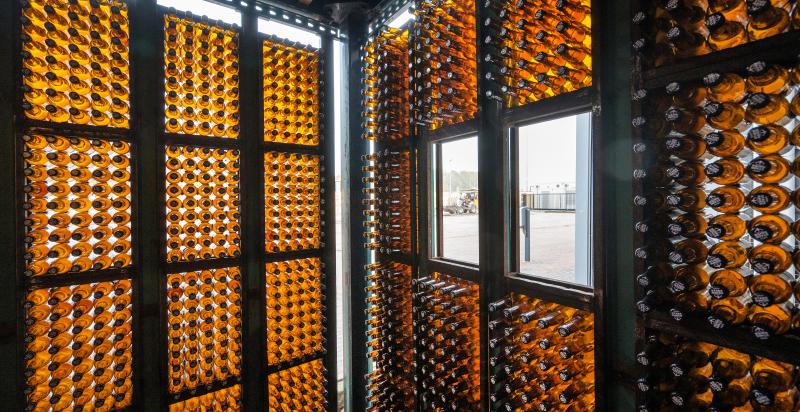 Binnenkant van een werkruimte in circulair gebouw De HER. De wanden zijn volledig opgebouwd uit lege bierflesjes