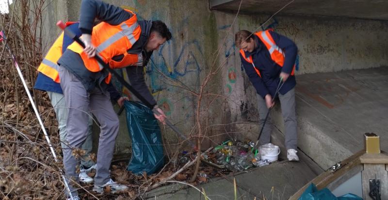 Twee mannen prikken vuilnis op 