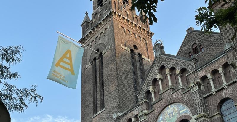 Arminiuskerk in Rotterdam met een vlag aan de gevel van Arminius debat