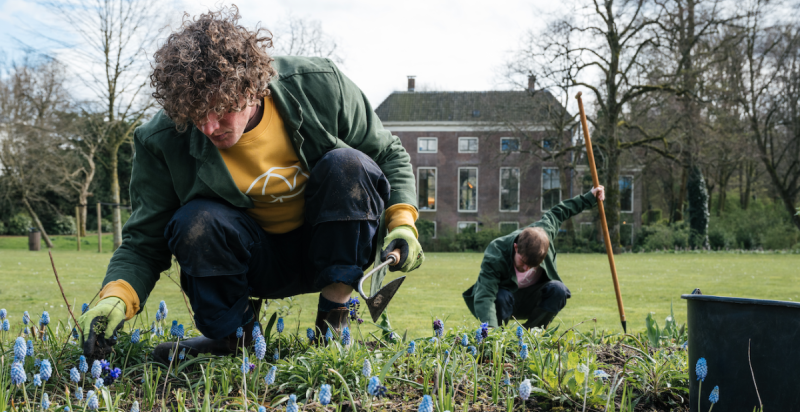 Twee mensen werken in de tuin voor een mooi monumentaal pand