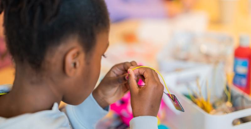 Een meisje is aan het knutselen.