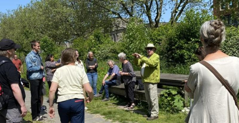 mensen krijgen een rondleiding in een park, een meneer geeft uitleg