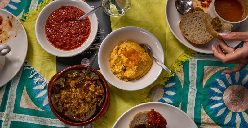 Een tafel met daarop een paar schaaltjes met dips gemaakt van geredde groenten.