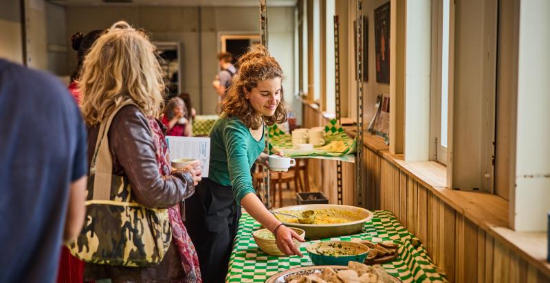 Vrouw schept eten op bij een buffet in De HER.