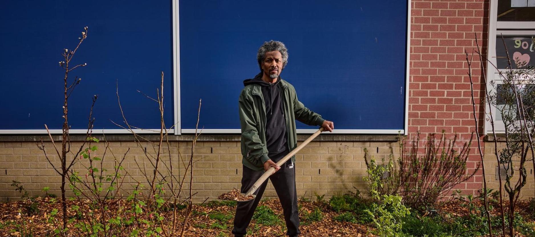 man met schep met houtsnippers