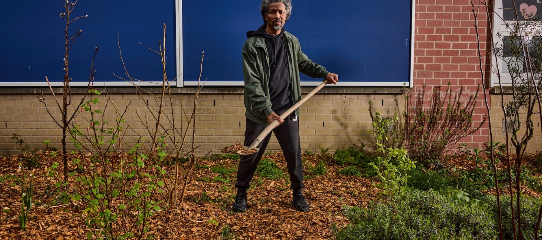 man met schep met houtsnippers