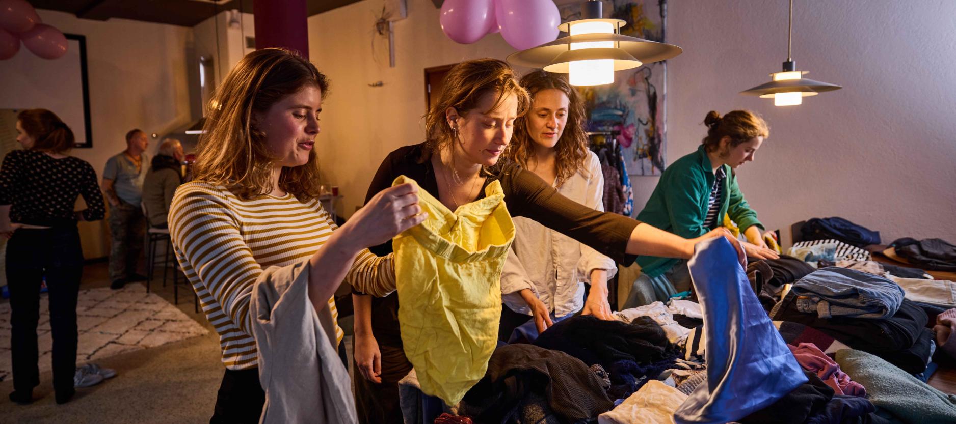 vier vrouwen bij een kledingruil