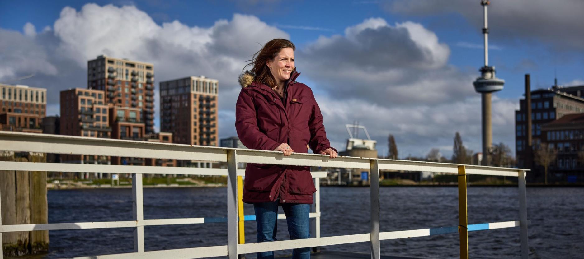 geposeerde foto van Linda van Rij, op een houten vlonder, op de achtergrond de Euromast en hoge gebouwen langs het water.