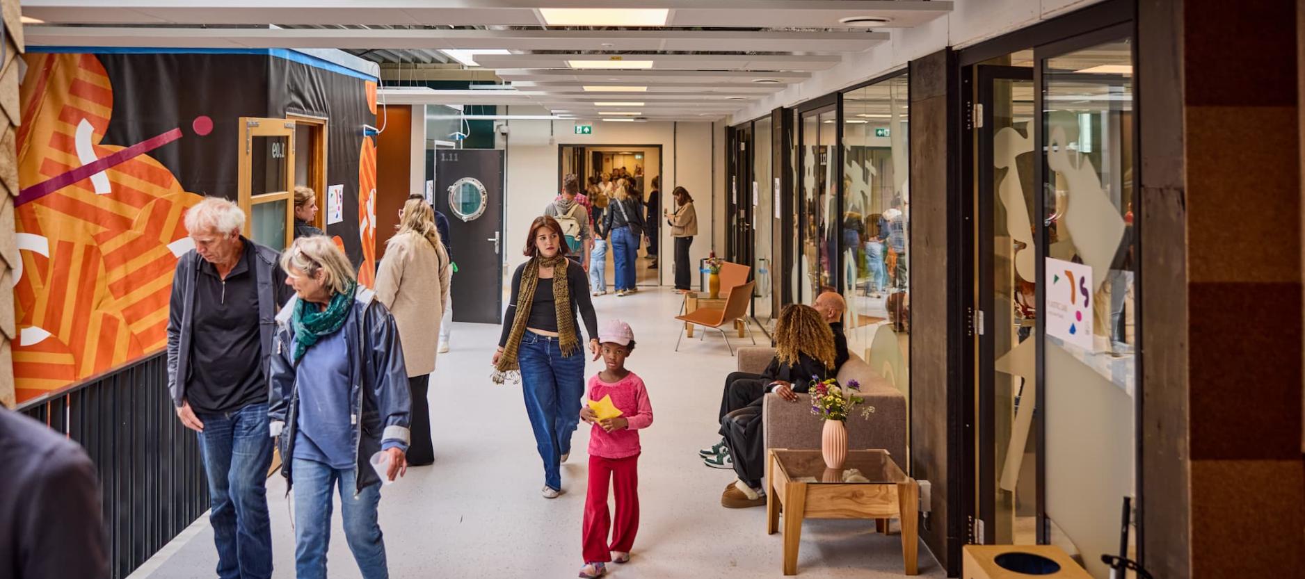 Verschillende mensen lopen door de hal op de eerste verdieping van circulair centrum De HER.