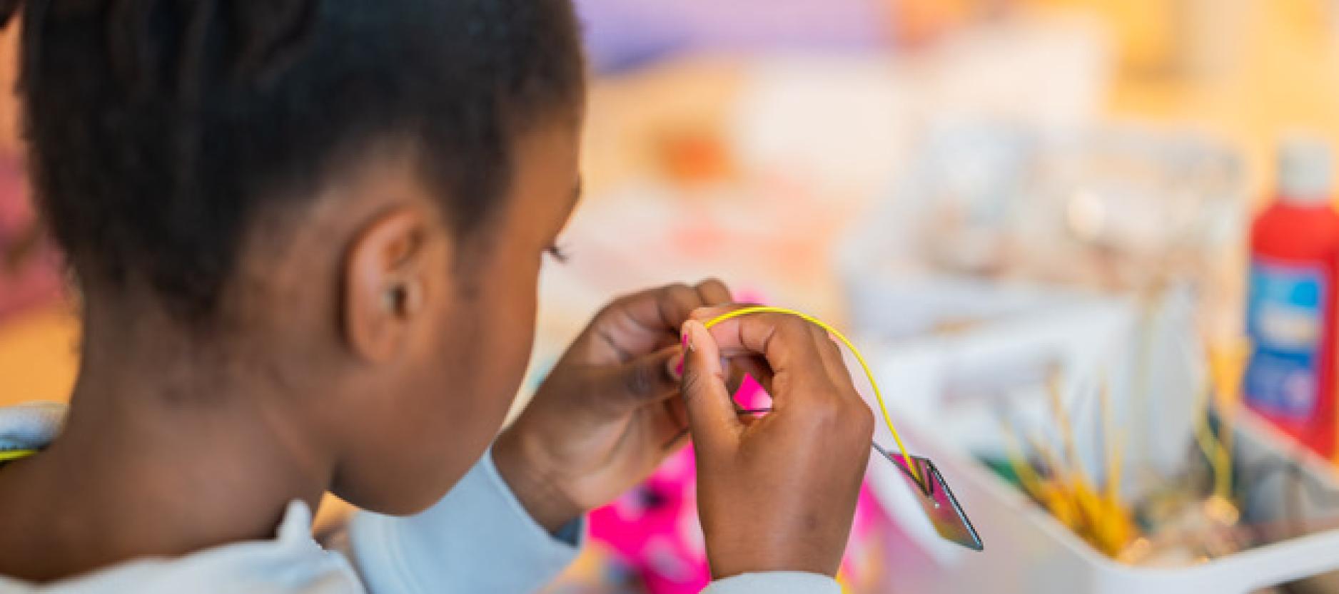 Een meisje is aan het knutselen.