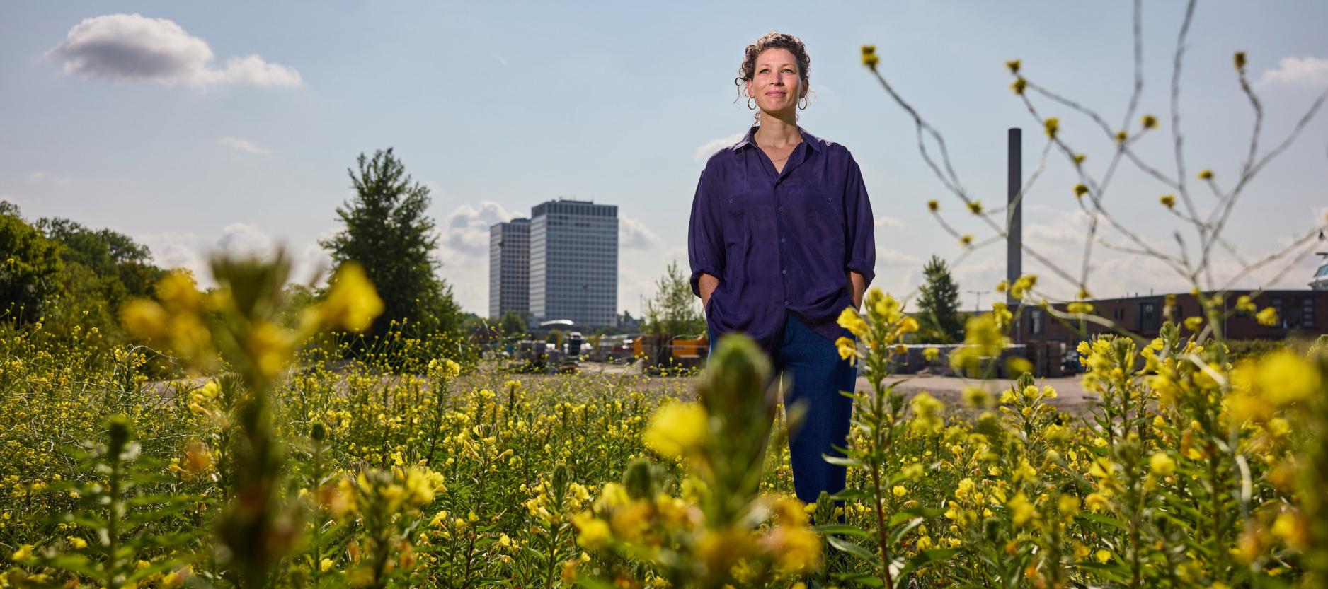 Sophie Duran in een veld vol gele bloemen met op de achtergrond de Marconi torens