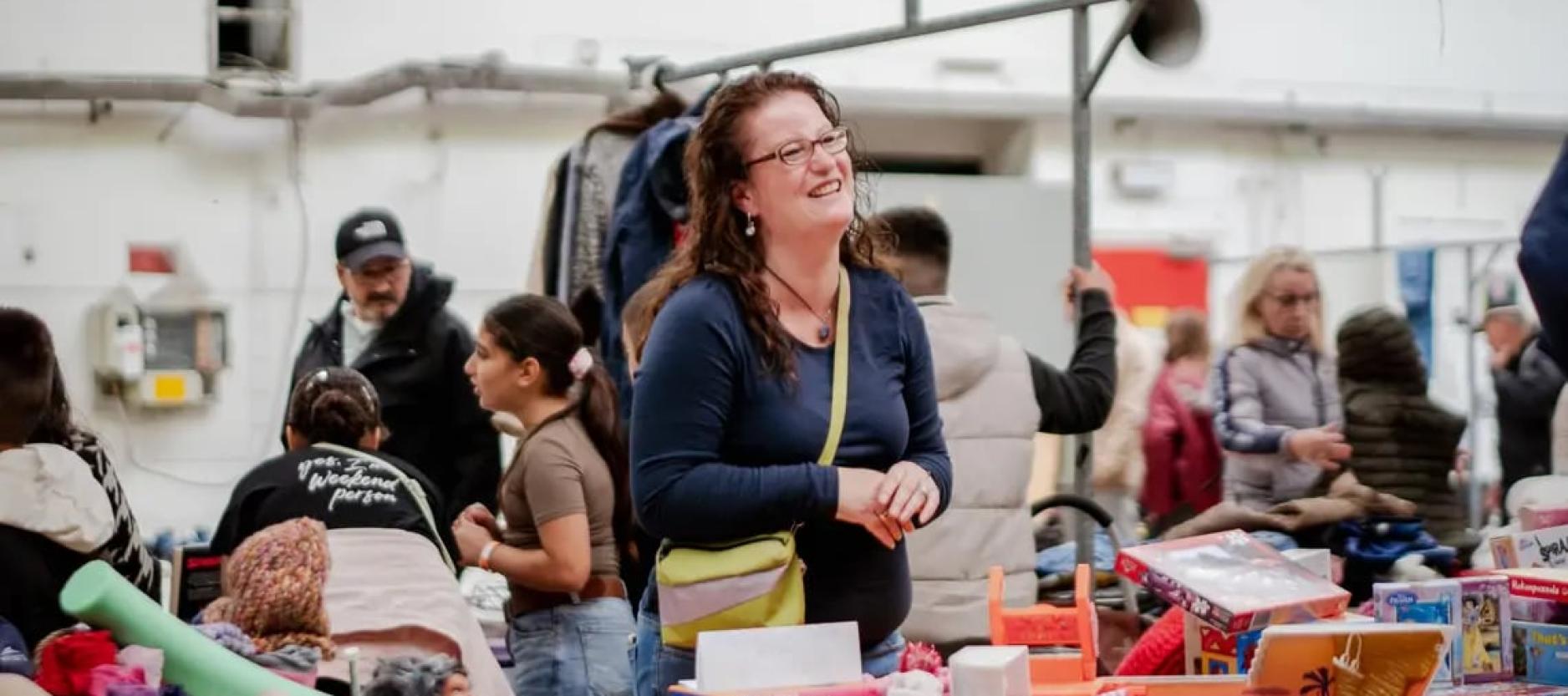 Vrouw glimlacht vanachter haar kraam op een markt
