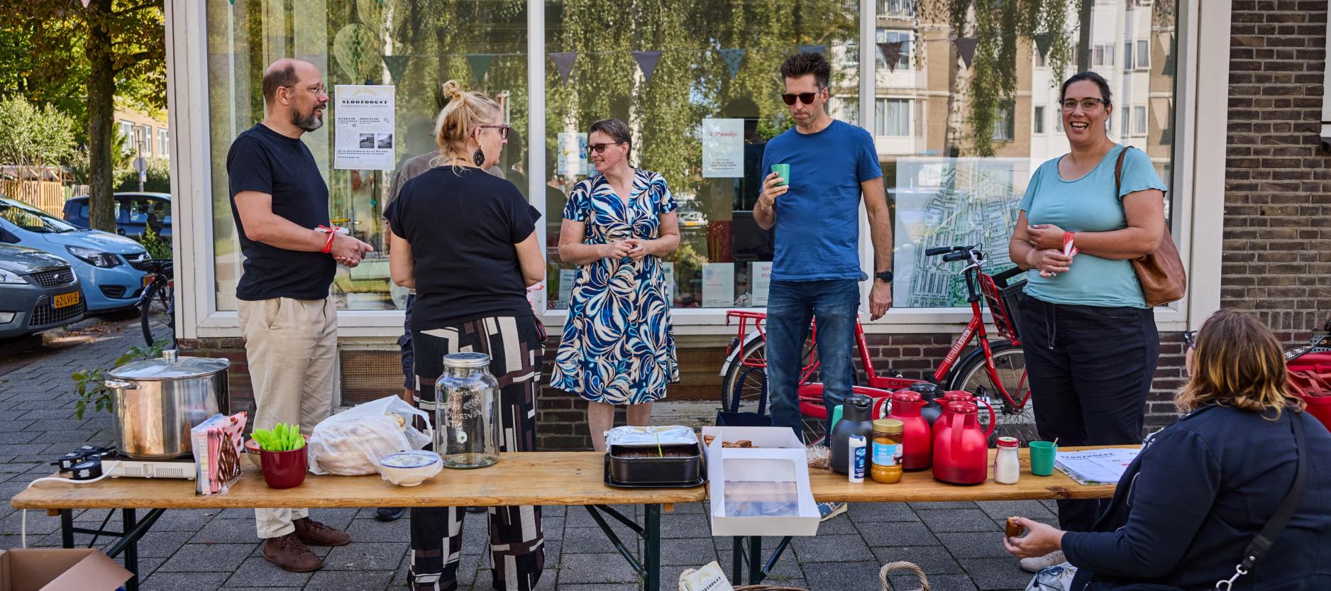 Groepje bewoners staat te praten voor het pand van wijkinitiatief Gouwe (Kl)ouwe in Carnisse.