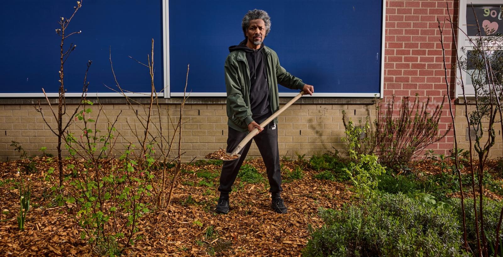 man met schep met houtsnippers