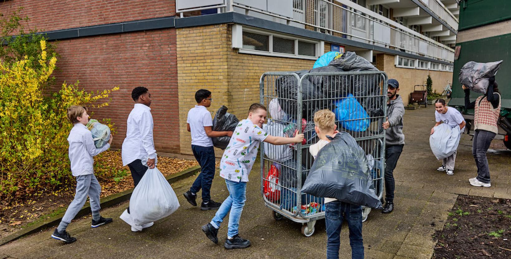 Leerlingen met zakken vol textiel