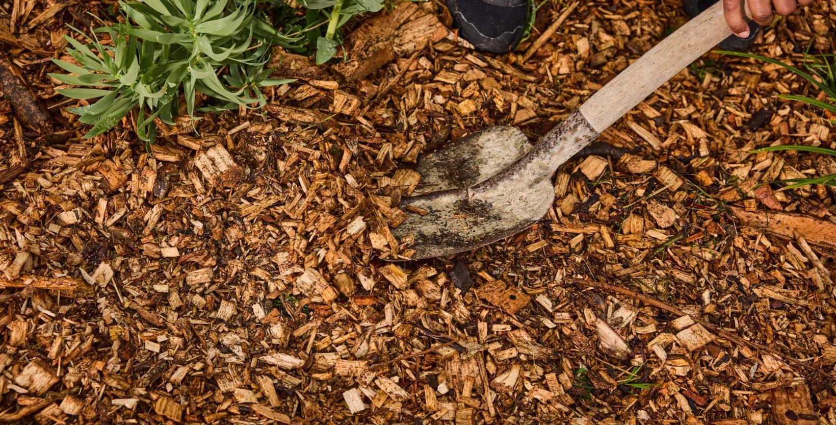 Op de foto houtsnippers met een schep.