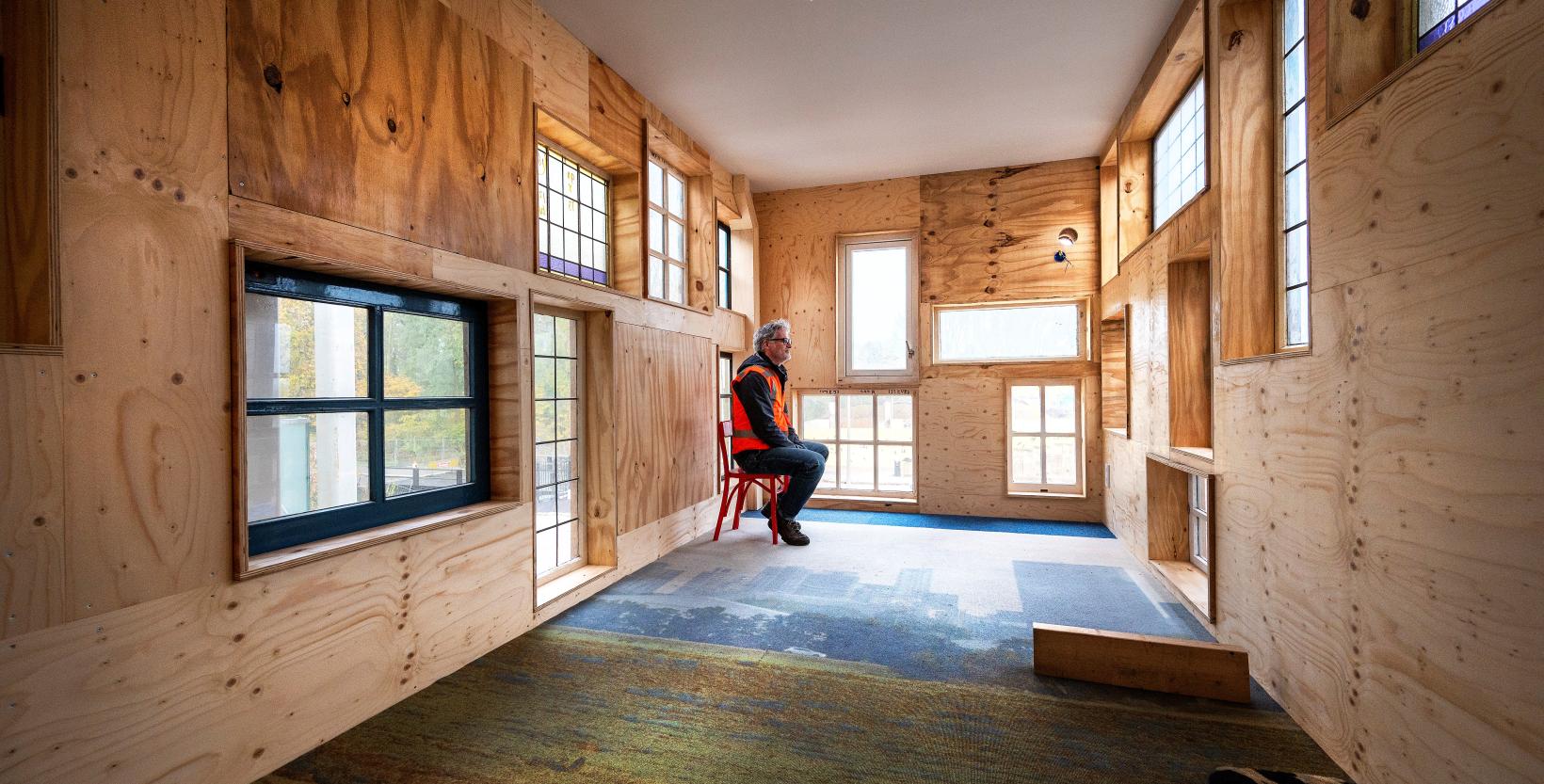 Man op een stoel in een van de werkruimtes van gebouw De HER. 