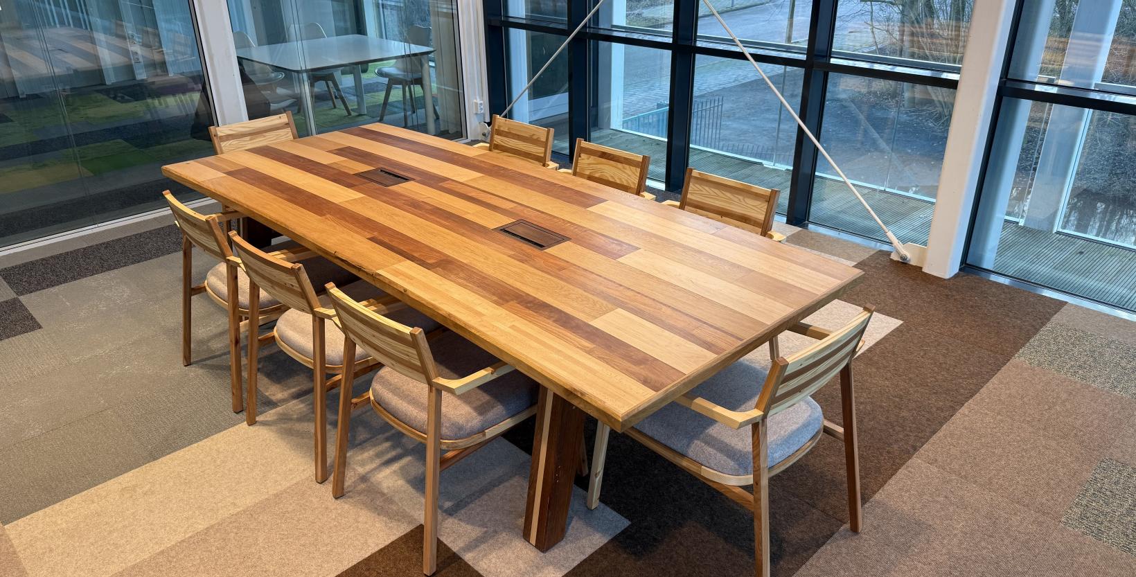 Een door studenten van het HMC gemaakte vergadertafel en acht stoelen. Allen gemaakt van ingeleverd milieuparkhout.