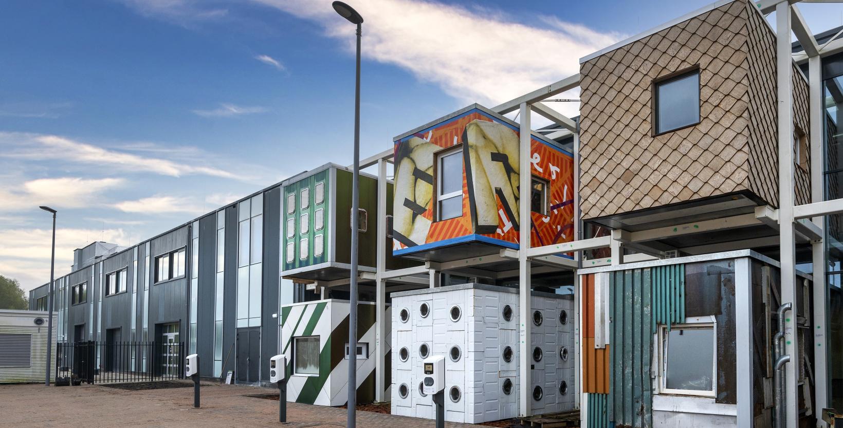 De voorgevel van circulair centrum De HER. Zes van de tien verschillende werkruimtes zijn goed zichtbaar.