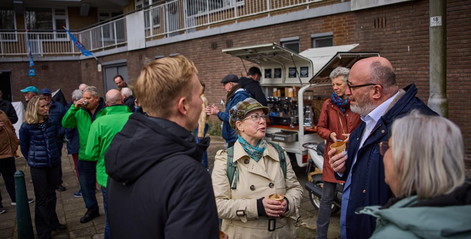 Bewoners drinken koffie tijdens overhandiging bokashi