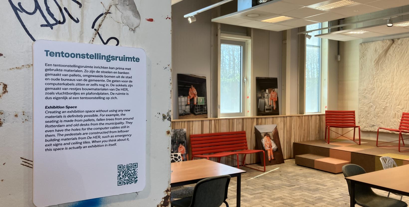 Klein stukje van de tentoonstellingsruimte in circulair centrum De HER. Er staan tafels met stoelen en een podium met een wollenkleed aan de achterwand.