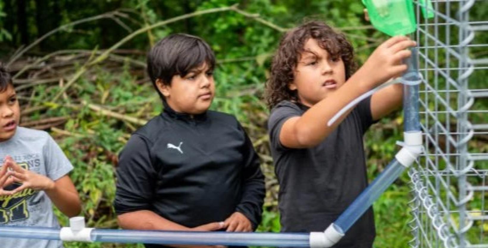 Foto van twee basisschoolscholieren die met buizen een constructie bouwen.