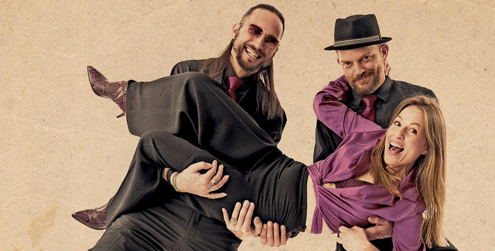 Twee mannen in pak tillen een vrouw op.