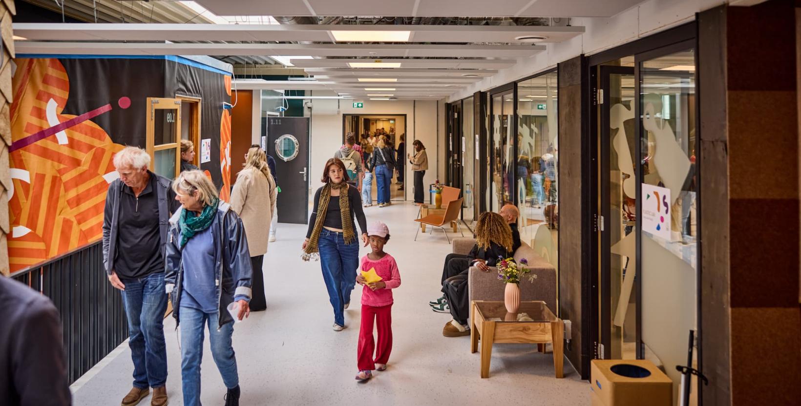 Verschillende mensen lopen door de hal op de eerste verdieping van circulair centrum De HER.