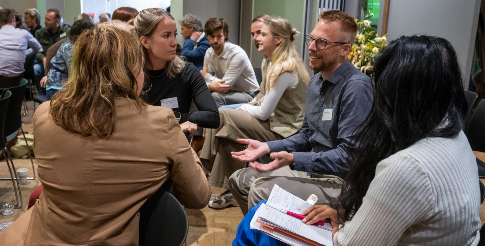 Groepje mensen met elkaar in gesprek tijdens een congres.